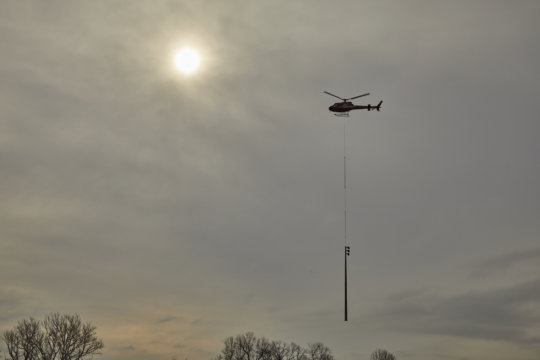 a helicopter setting poles at the Gathering Place