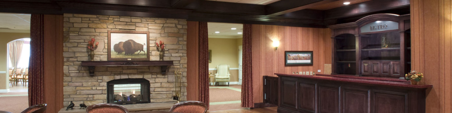 an interior lounge area with tables and a fireplace